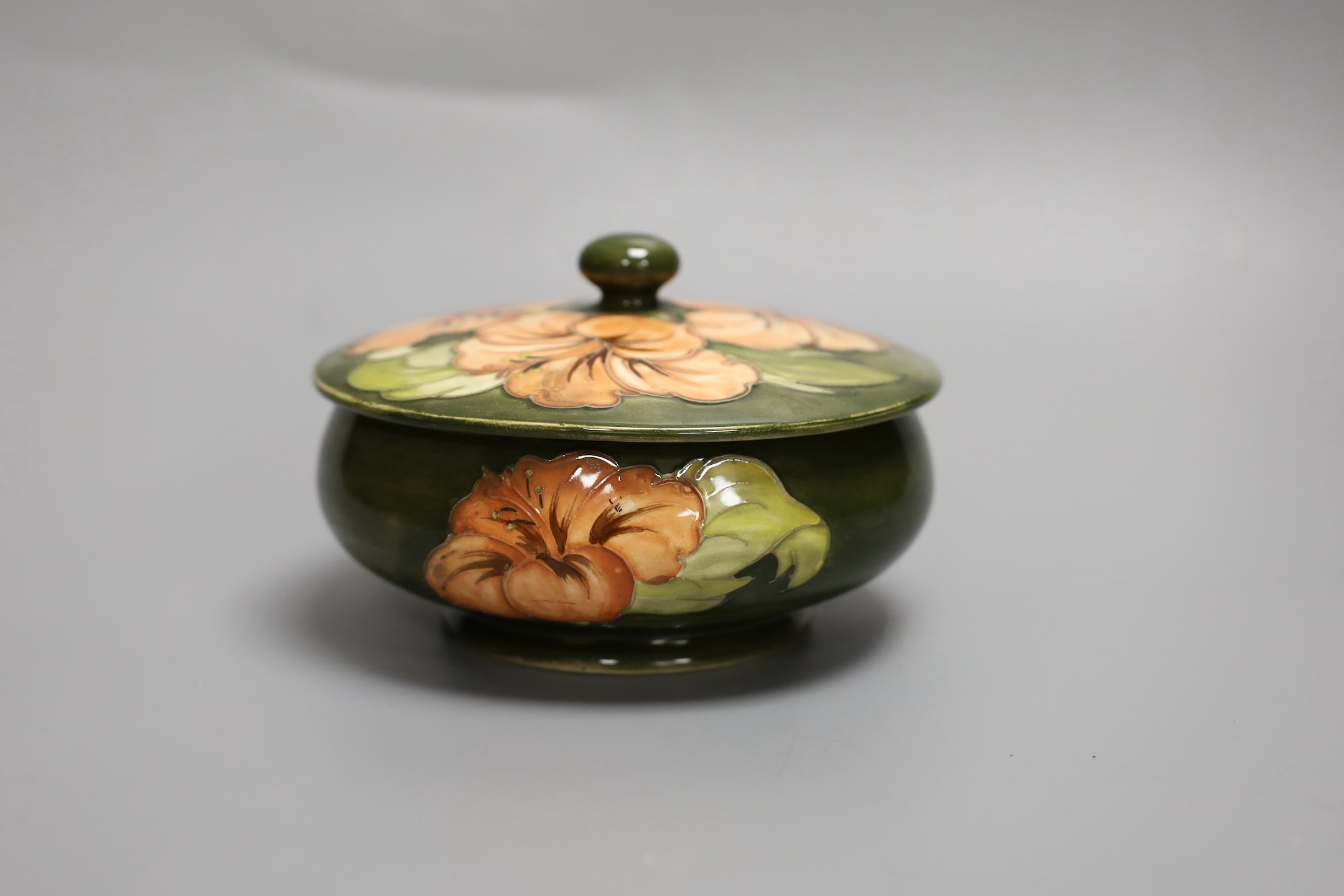 A Moorcroft hibiscus pattern powder bowl and cover, 15cm diam.
